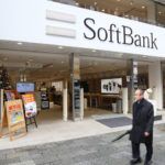 Tokyo: People walk by SoftBank mobile phone network store in Tokyo, Japan. There are 146.6 million mobile phones in use in Japan (2013).