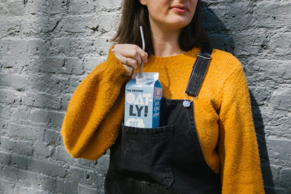 Oatly carton in dungarees