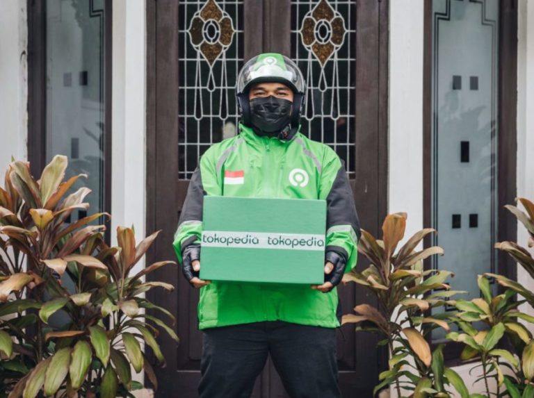 Gojek driver delivering Tokopedia package to signify merger